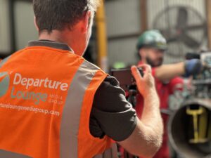 A man taking a picture on a tripod for the Departure Lounge group
