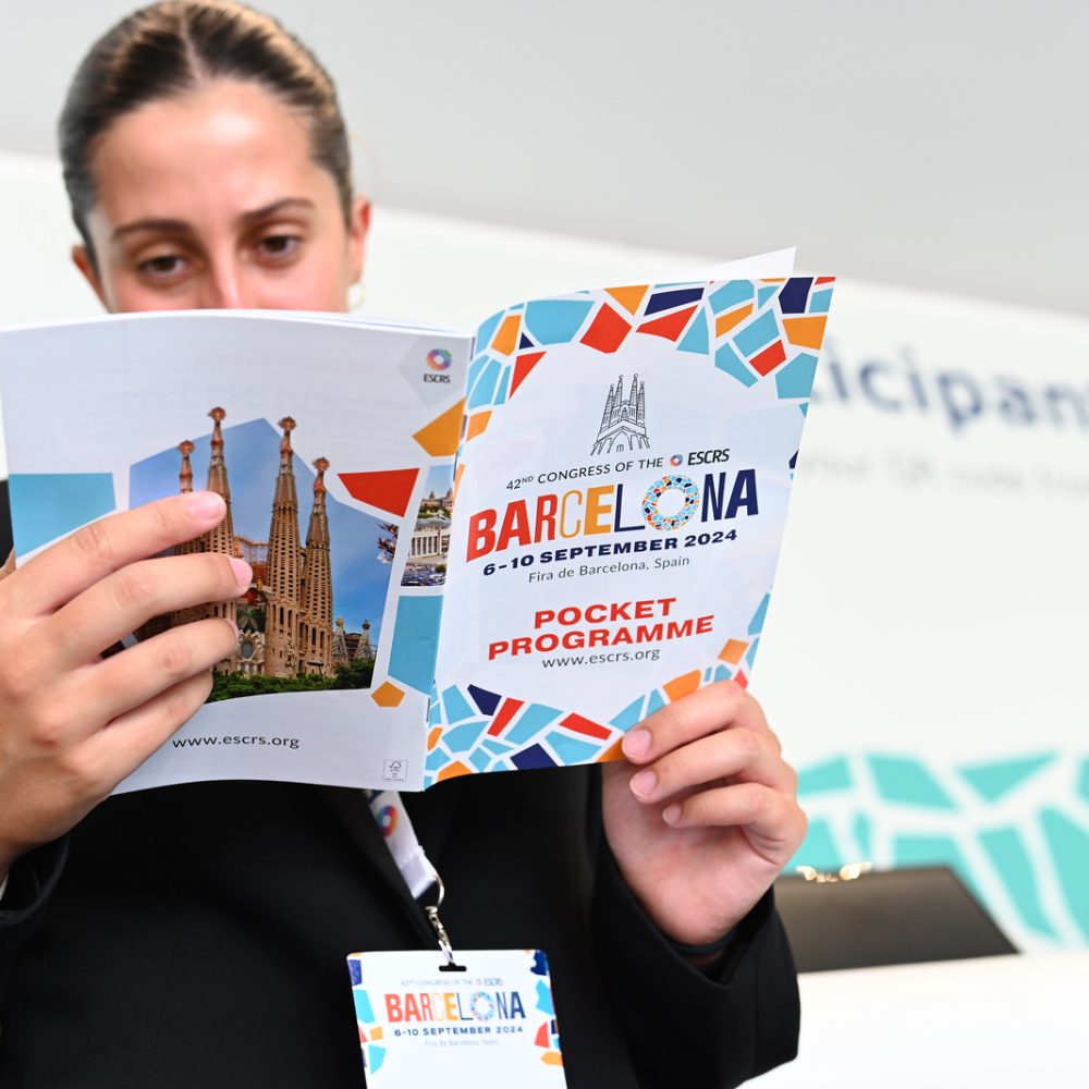 A woman holding a ESCRS brochure